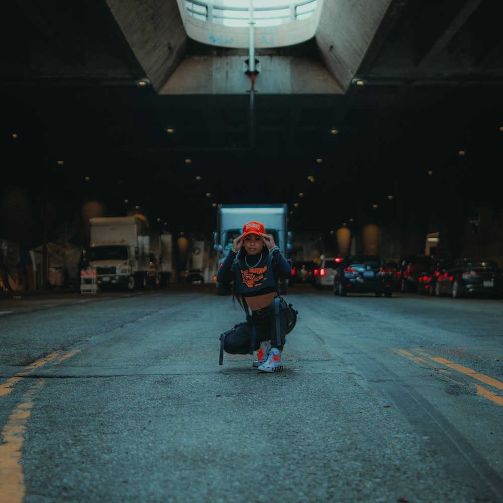 a man kneeling down on the ground in a parking garage