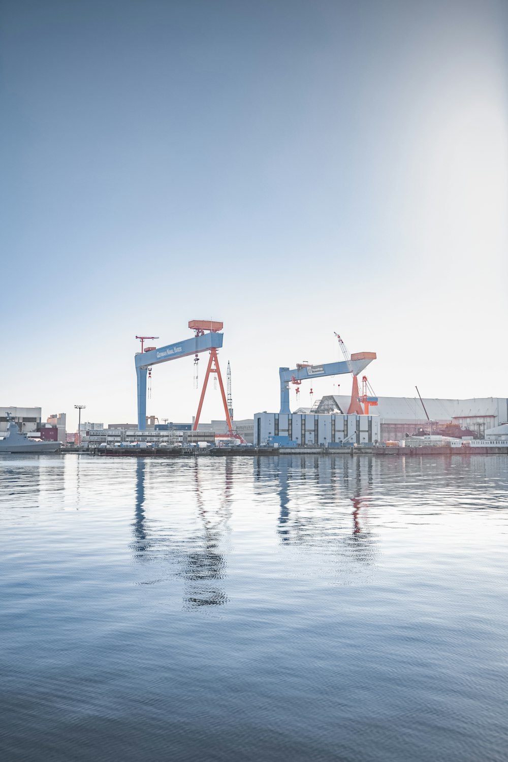 a large body of water with some cranes in the background