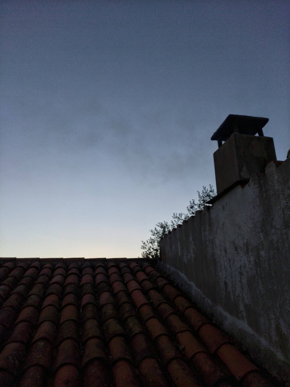 a view of the roof of a building at dusk