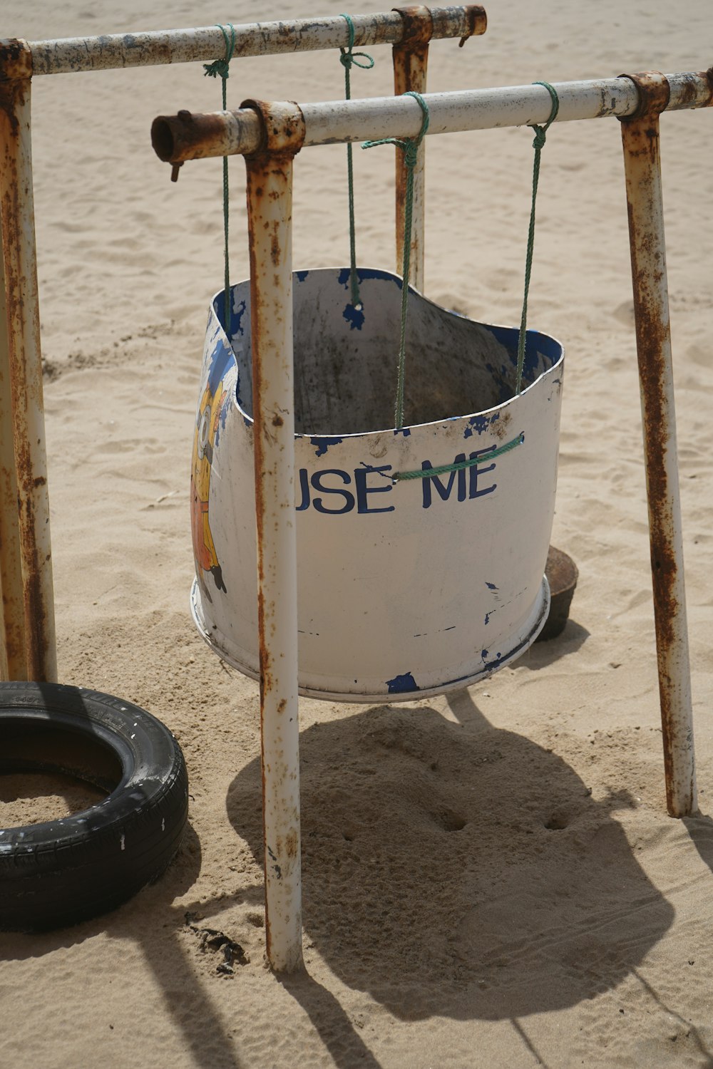 a tire and a bucket on a beach