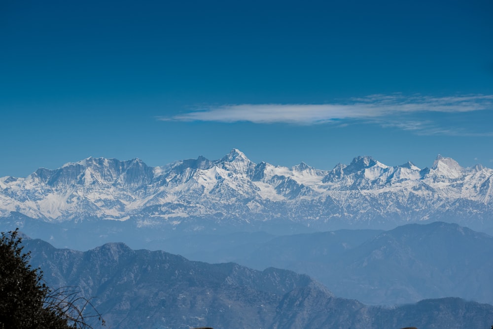 a mountain range with snow capped mountains in the distance