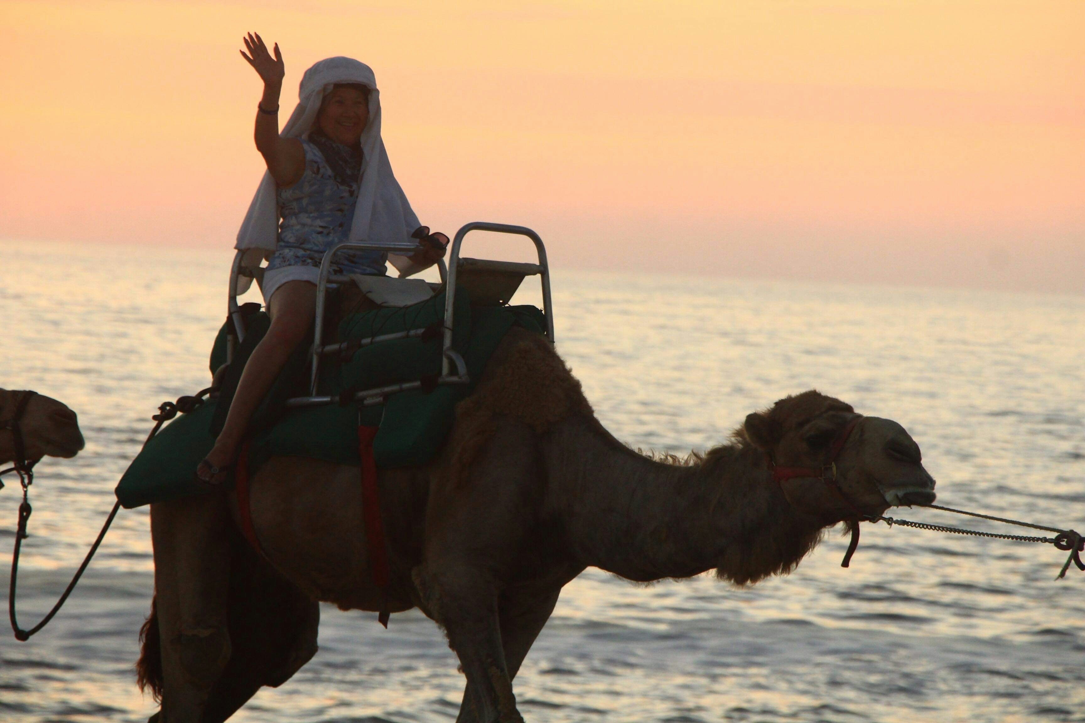 A woman riding on the back of a camel in the desert of Cabo San Lucas, Mexico. [Photo by Snowball Escandon on Unsplash