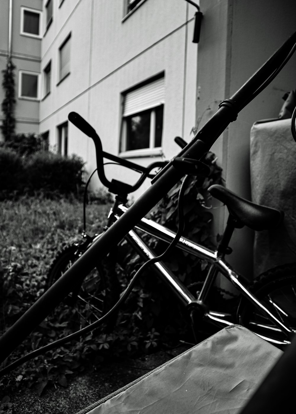 a black and white photo of a bicycle leaning against a building
