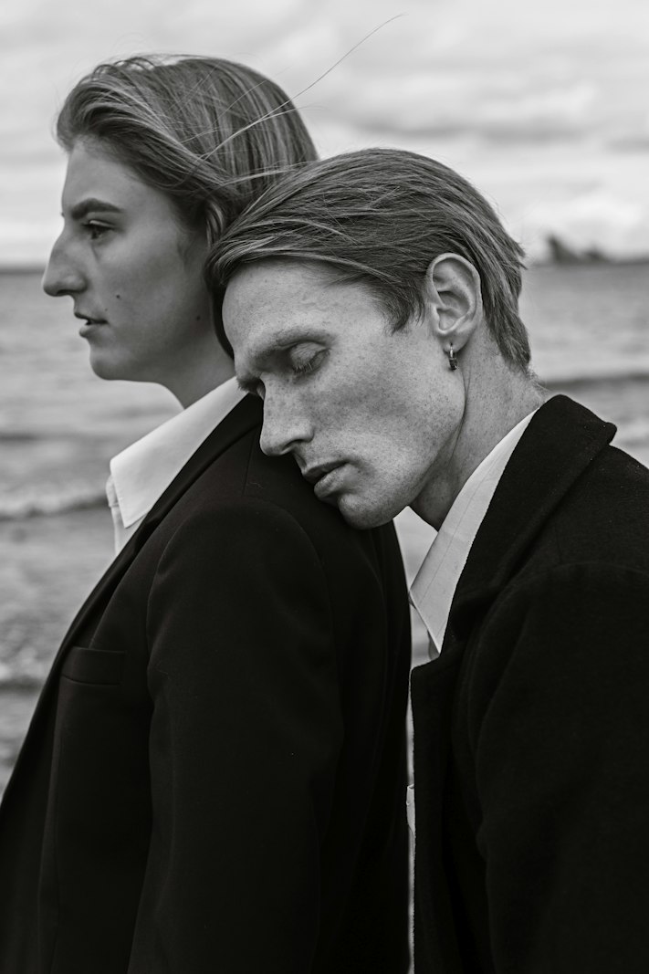 Un couple en manteaux sombres au bord de la mer, noir et blanc