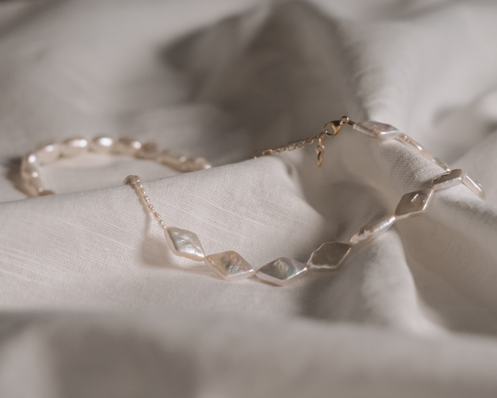 a close up of a piece of jewelry on a bed