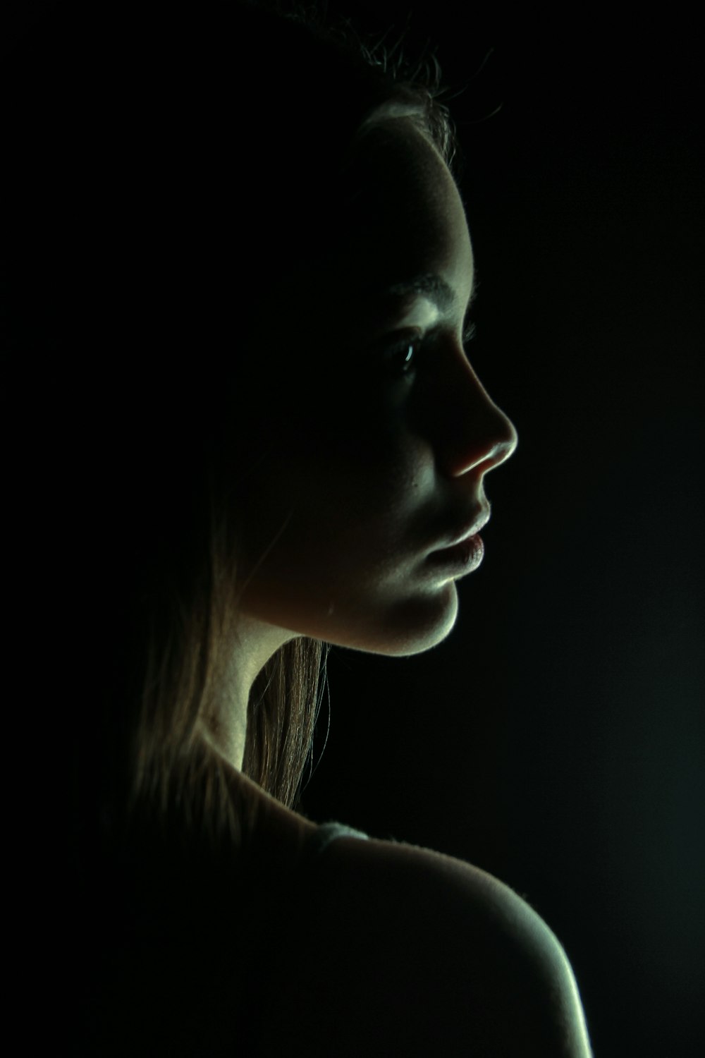 a woman in the dark with a cell phone in her hand