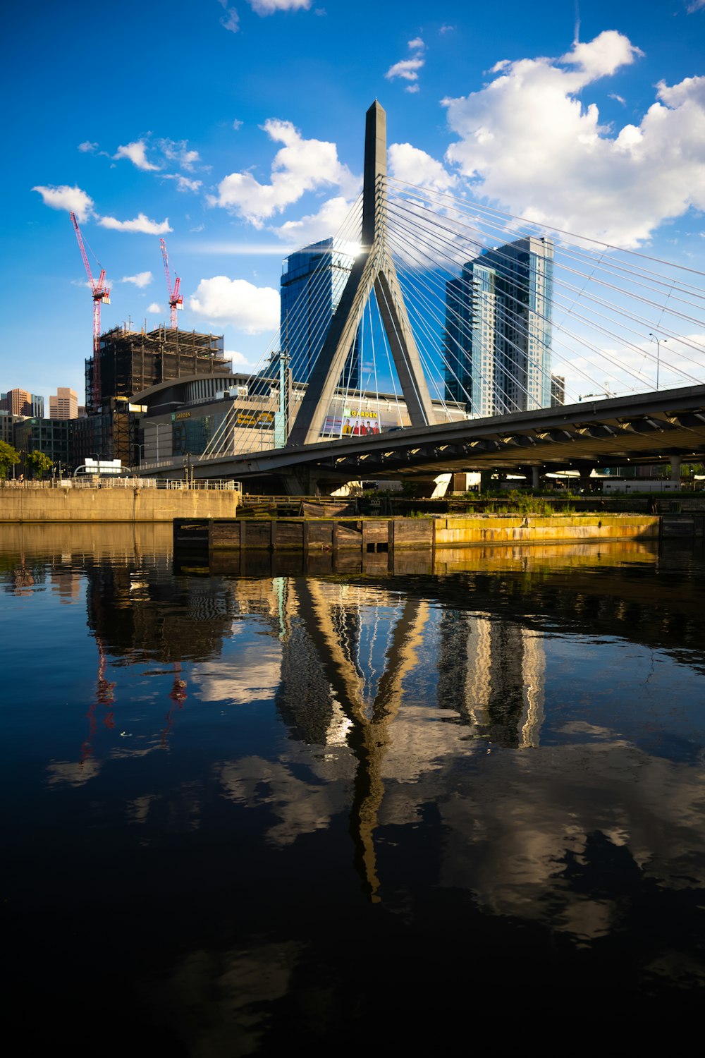 a bridge over a body of water with buildings in the background