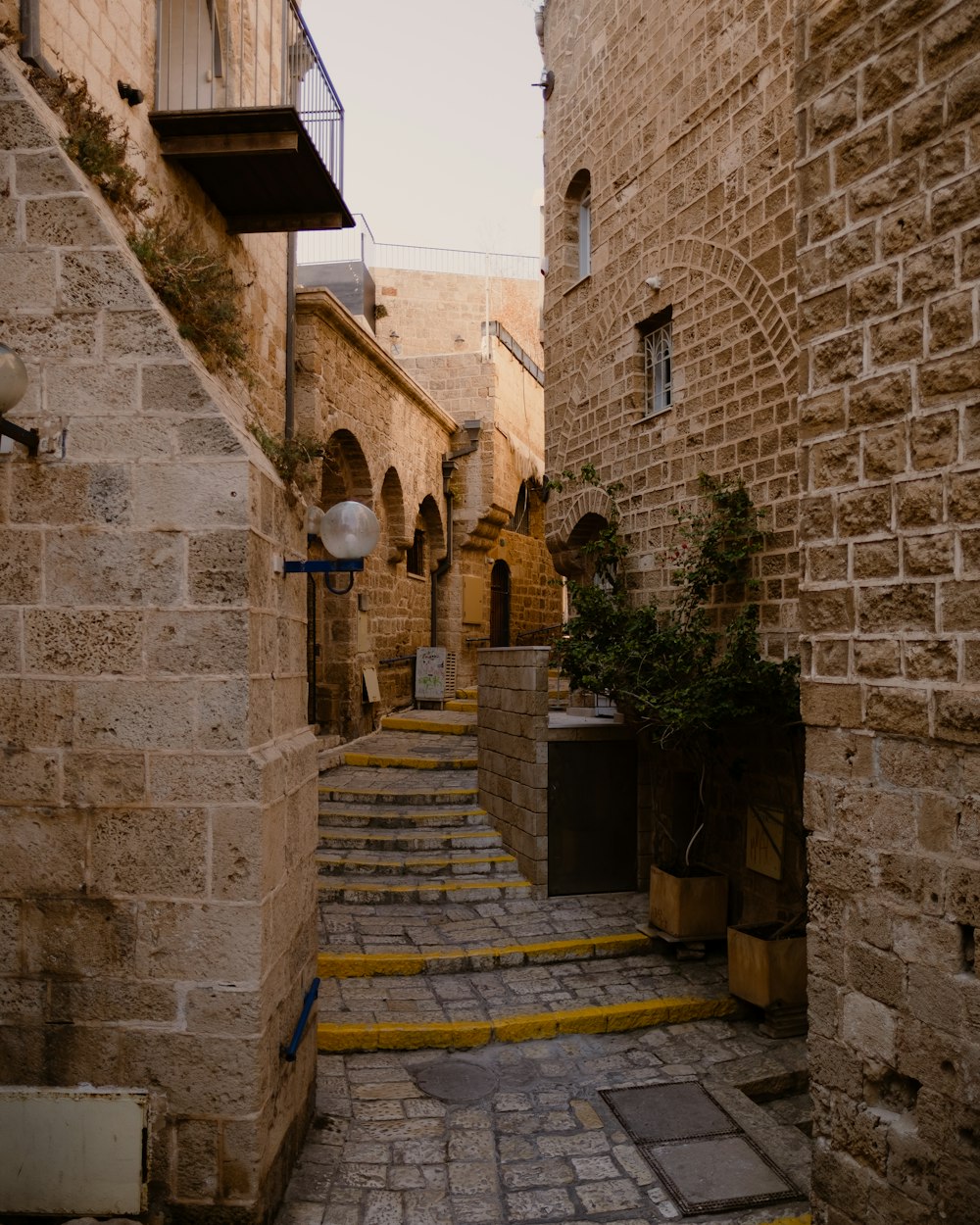 a stone building that has a bench in front of a brick wall