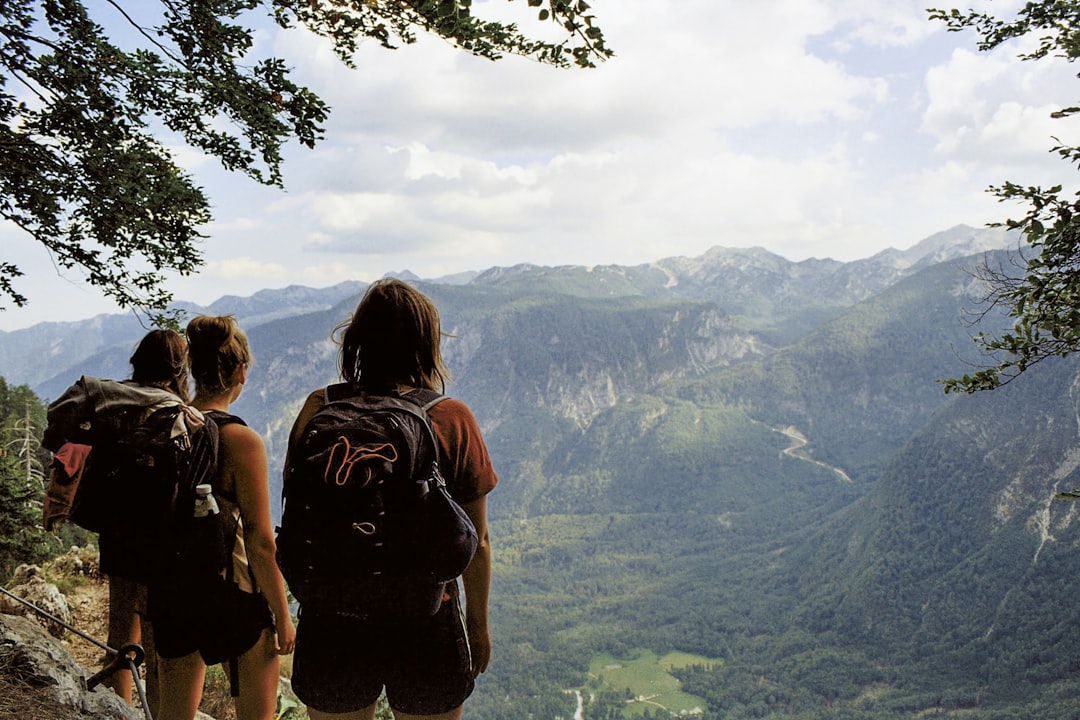 a couple of people standing on top of a mountain,