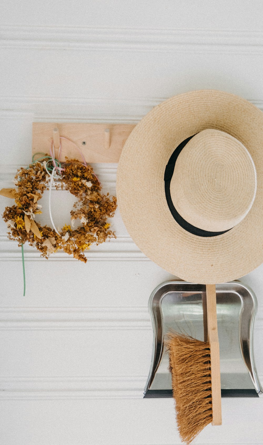 a hat, broom, and wreath on a wall