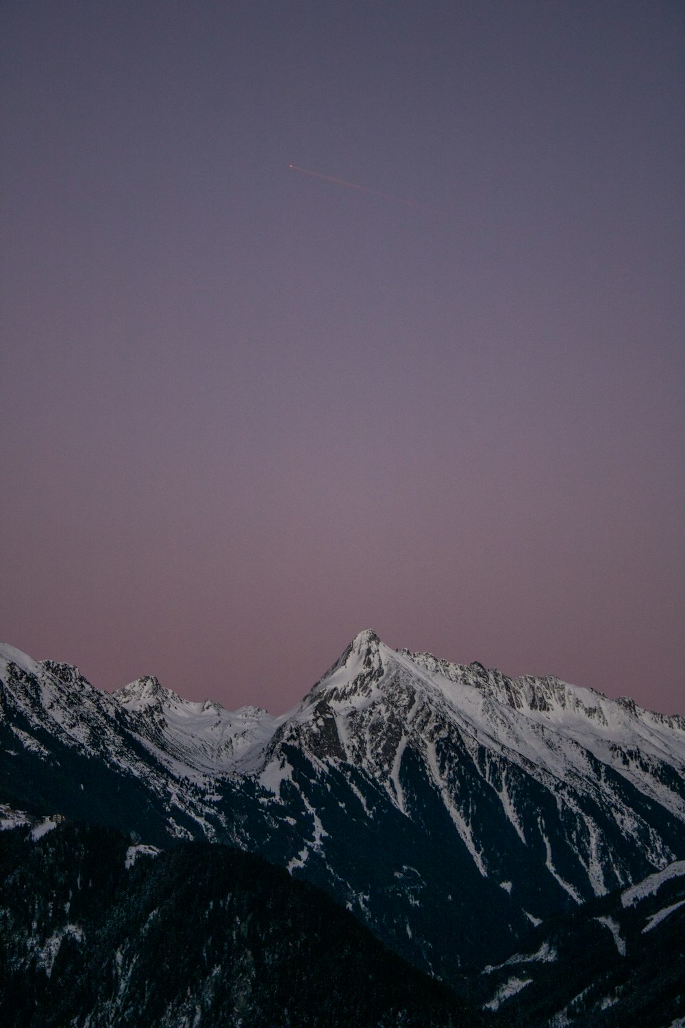 a plane flying over a snowy mountain range