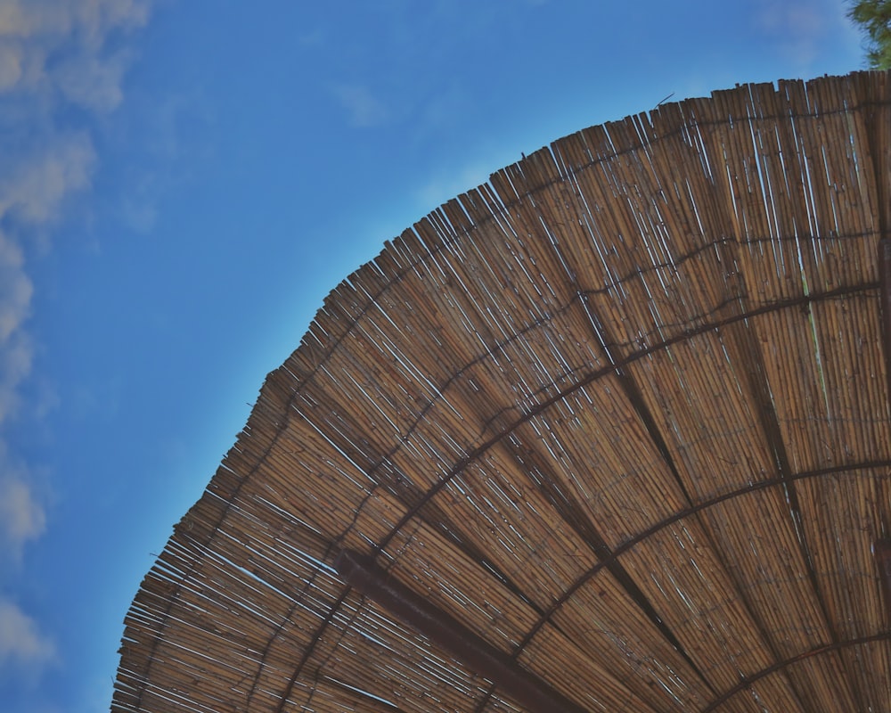 a close up of a bamboo umbrella against a blue sky