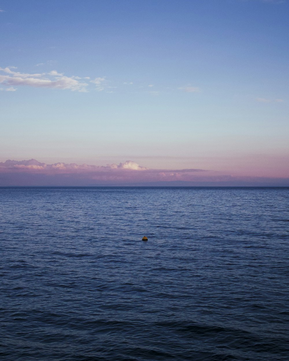 a body of water with a sky in the background