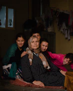 A caring Bangladeshi housemaid playing with children in a living room.