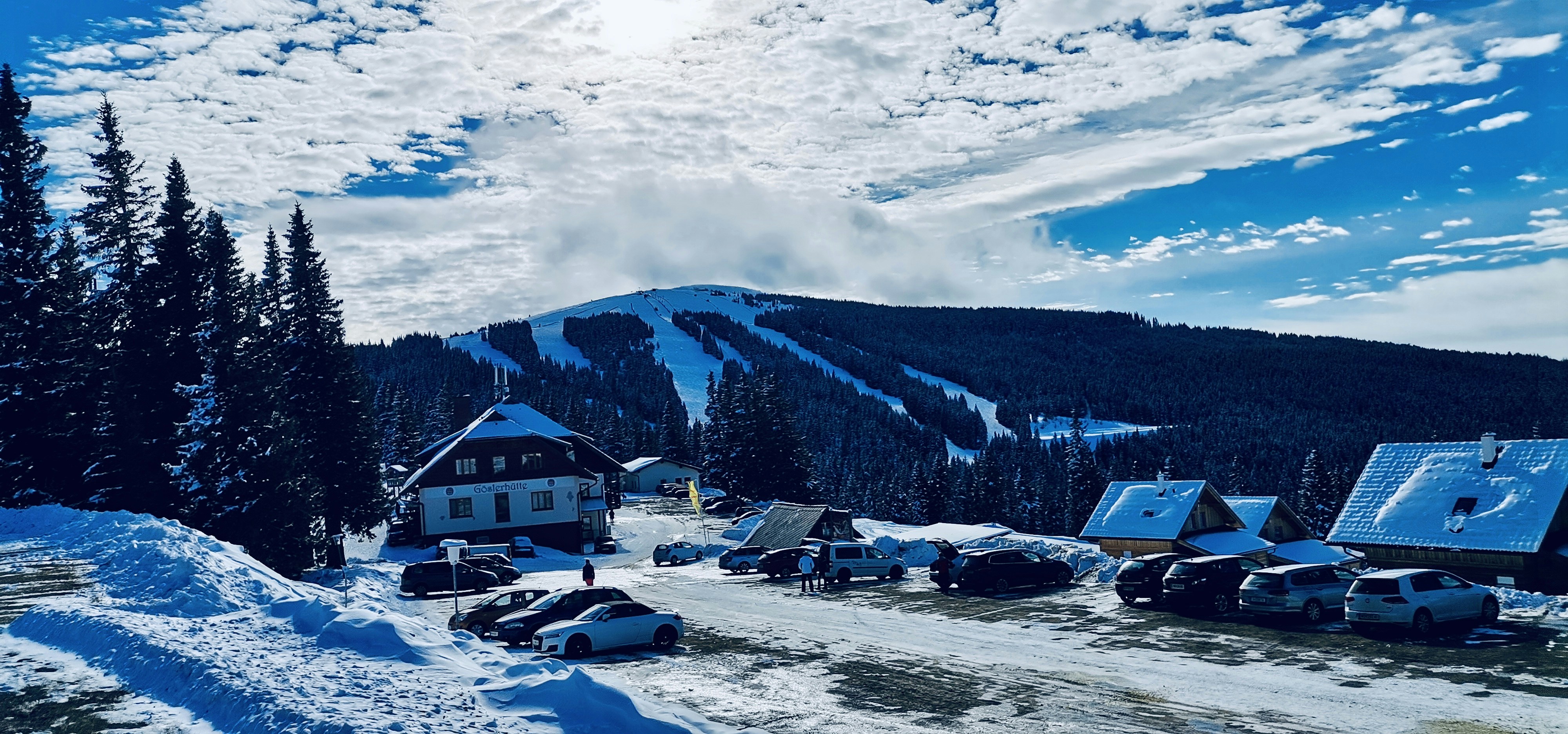 uma estrada coberta de neve com uma montanha ao fundo