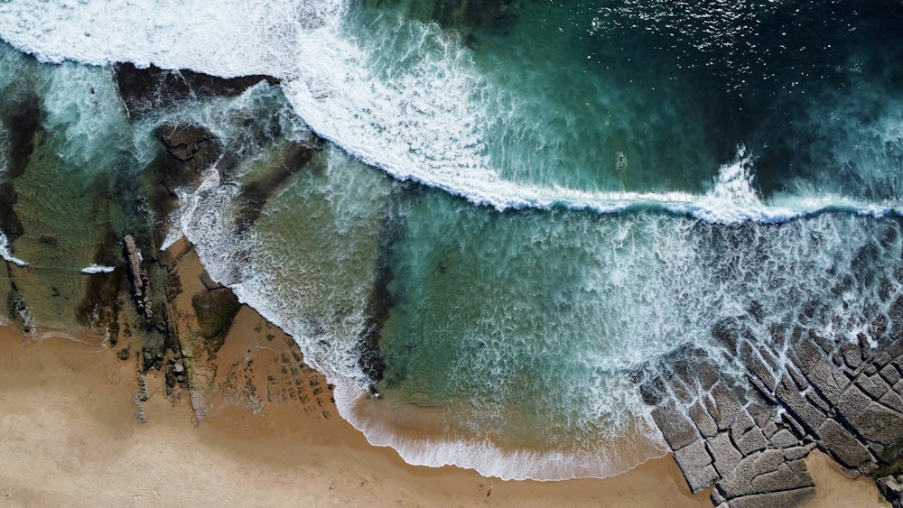 an aerial view of a beach with waves crashing on it