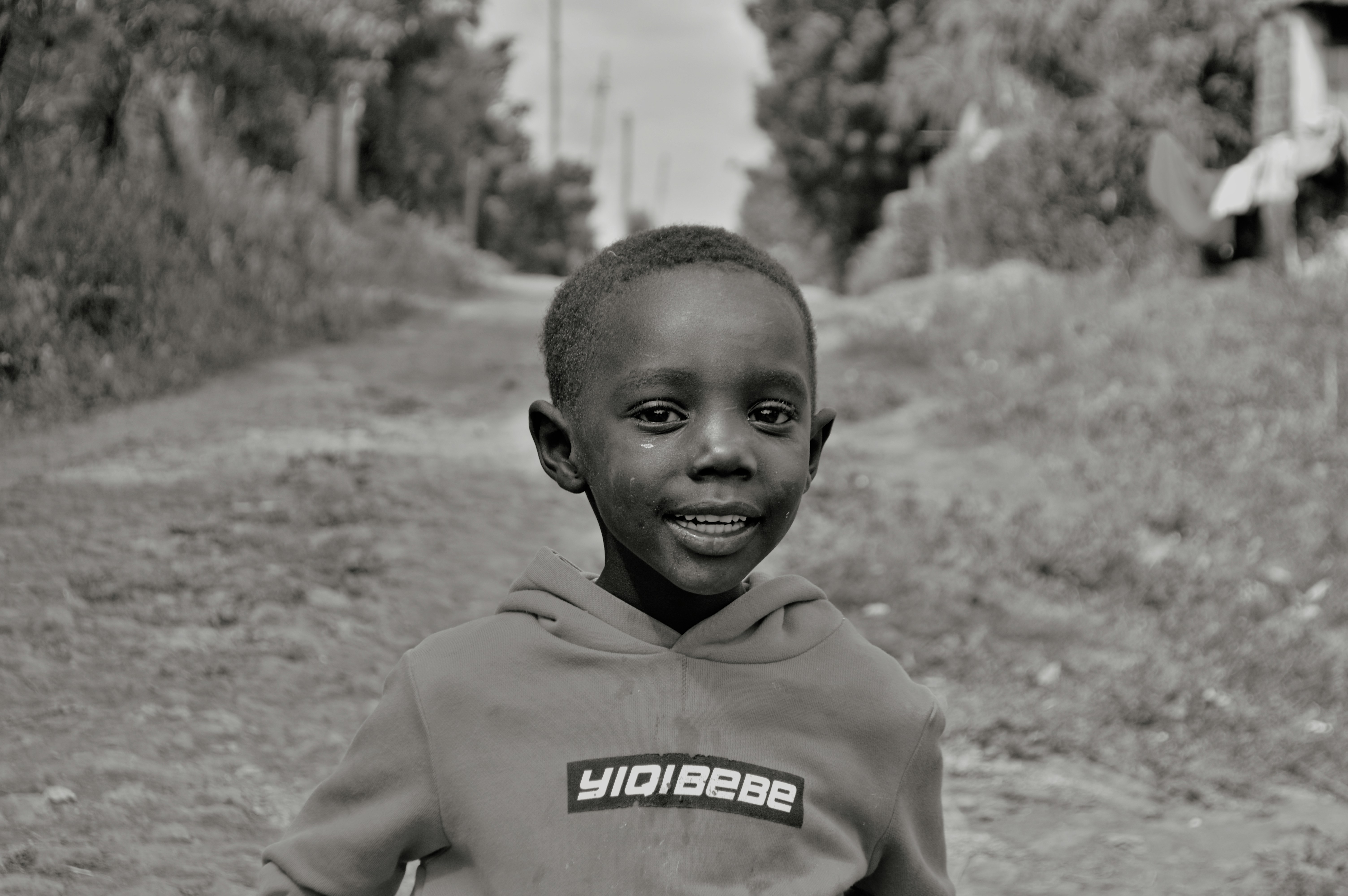 a young boy is standing in the dirt
