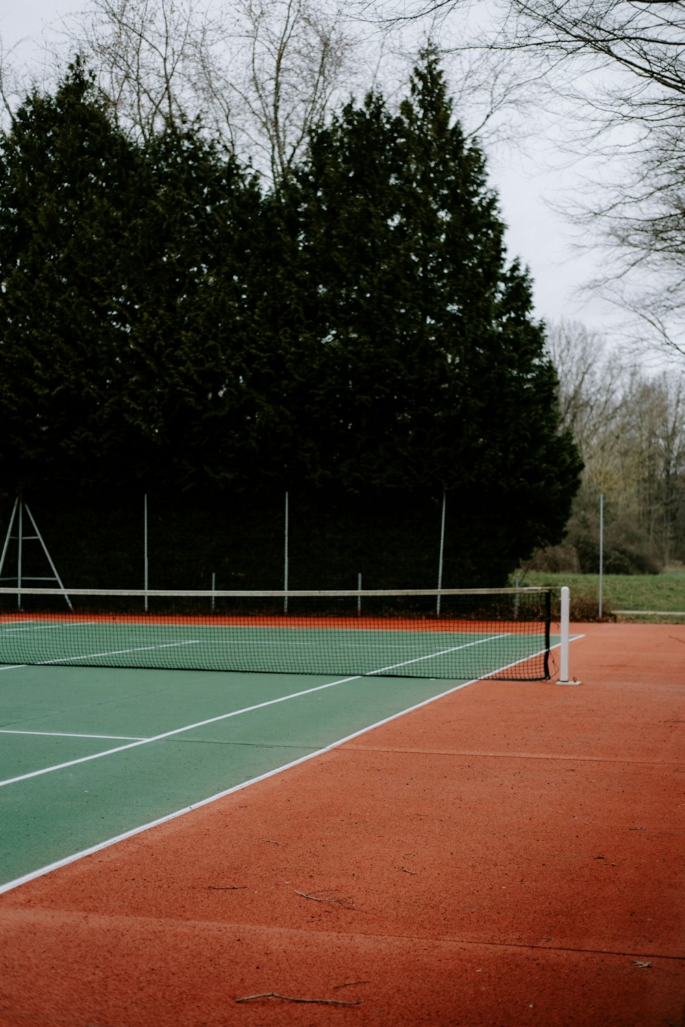 Un court de tennis avec un filet et des arbres en arrière-plan