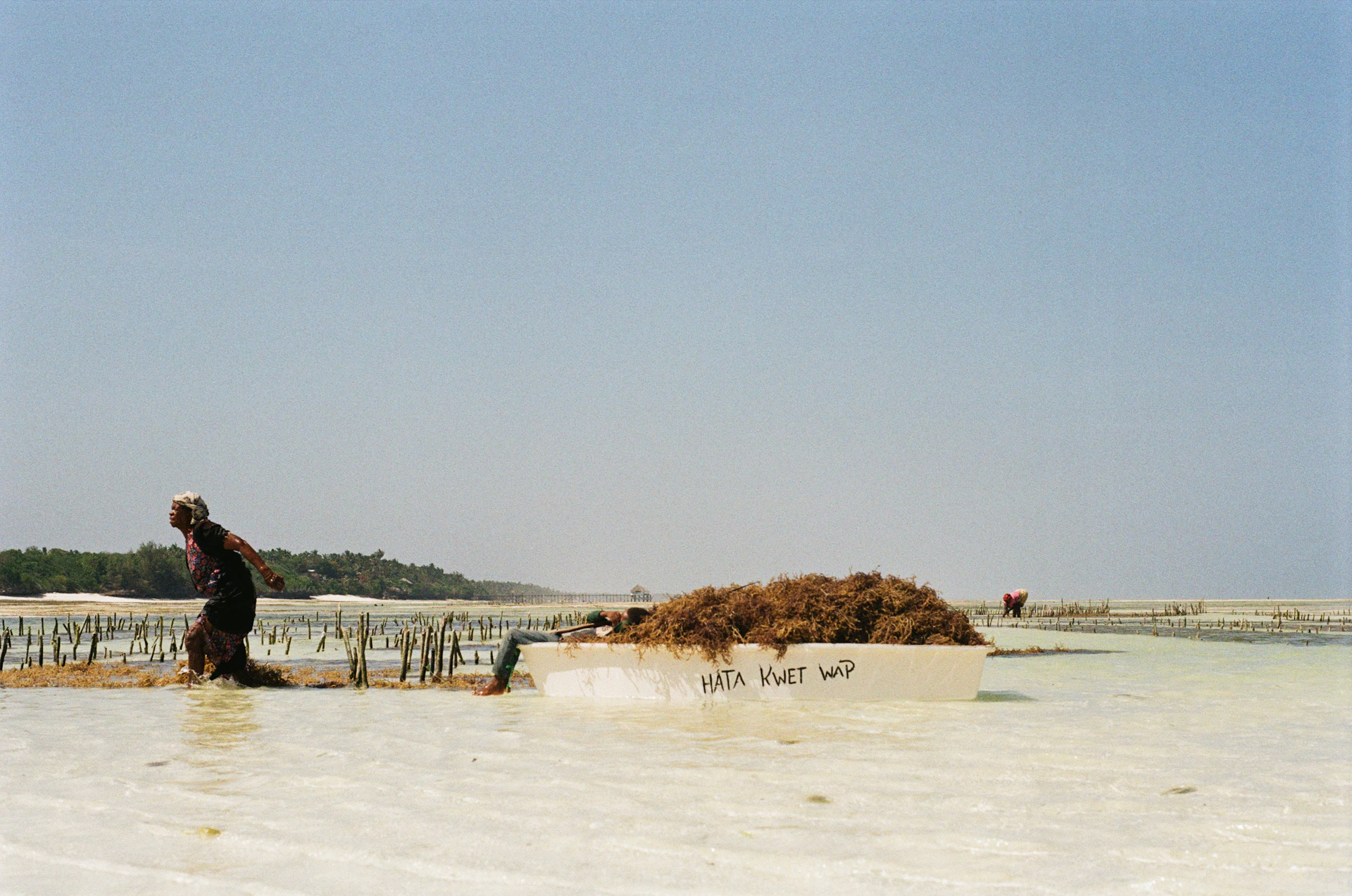 a man standing in a body of water next to a boat