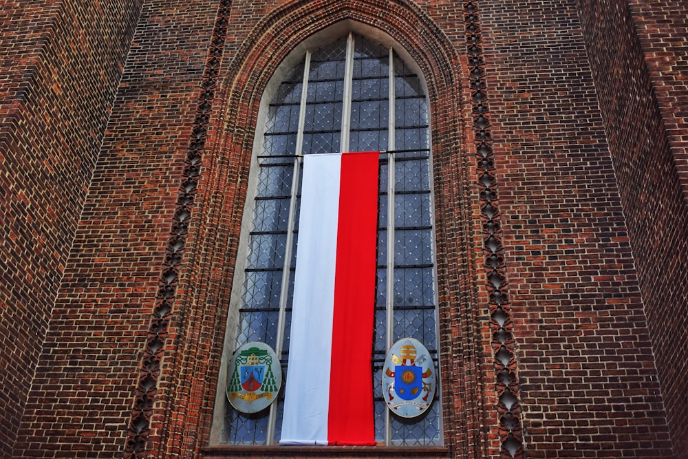 a tall brick building with a red white and blue flag hanging from it's
