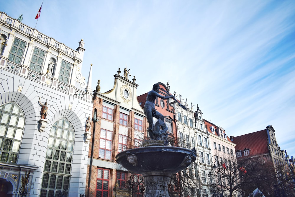 a statue of a man on a fountain in front of a building