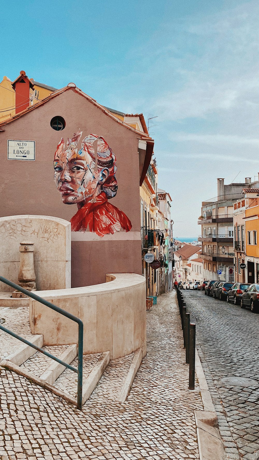 a mural on the side of a building on a cobblestone street