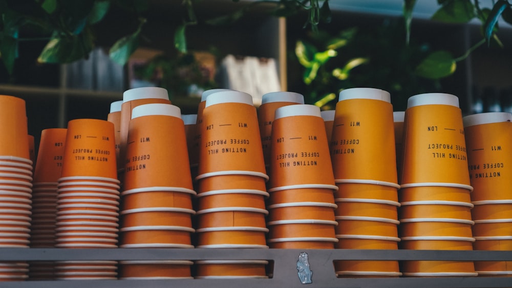 a shelf filled with orange cups sitting next to each other