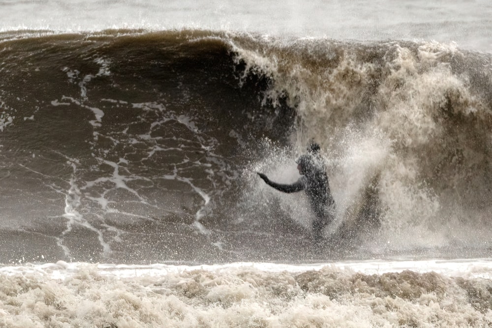 a man riding a wave on top of a surfboard