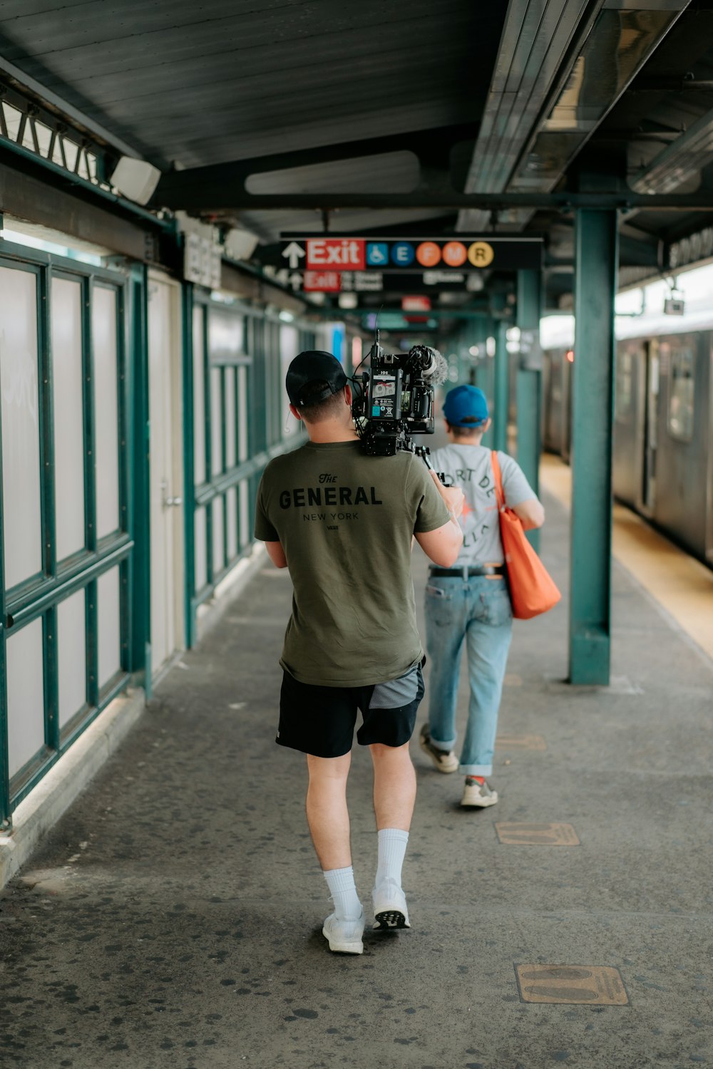 a man with a camera on a subway platform