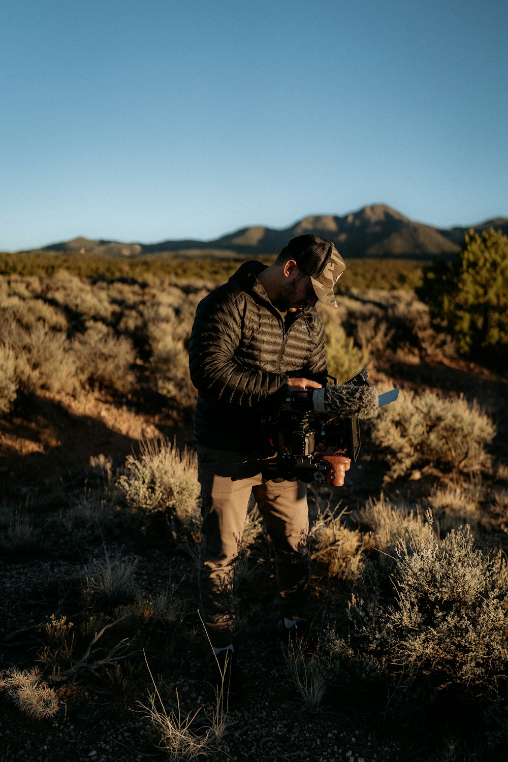 a man standing in a field holding a camera