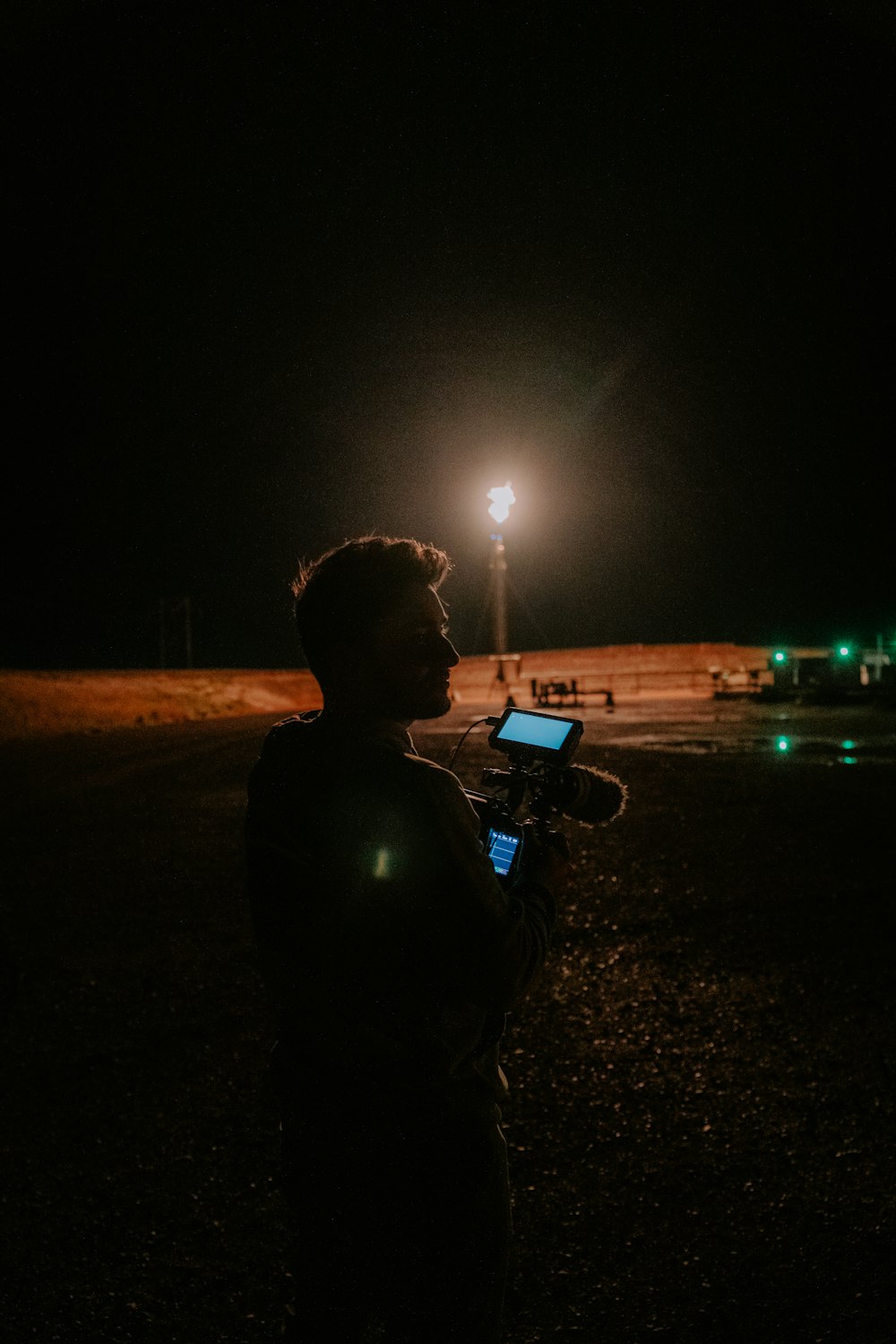 a man standing in the dark holding a cell phone