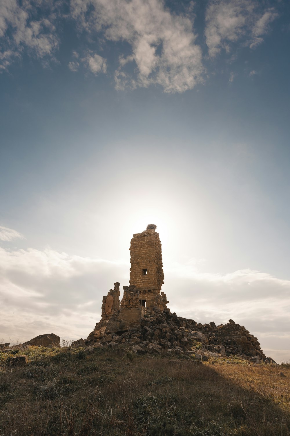 a large tower sitting on top of a grass covered hill