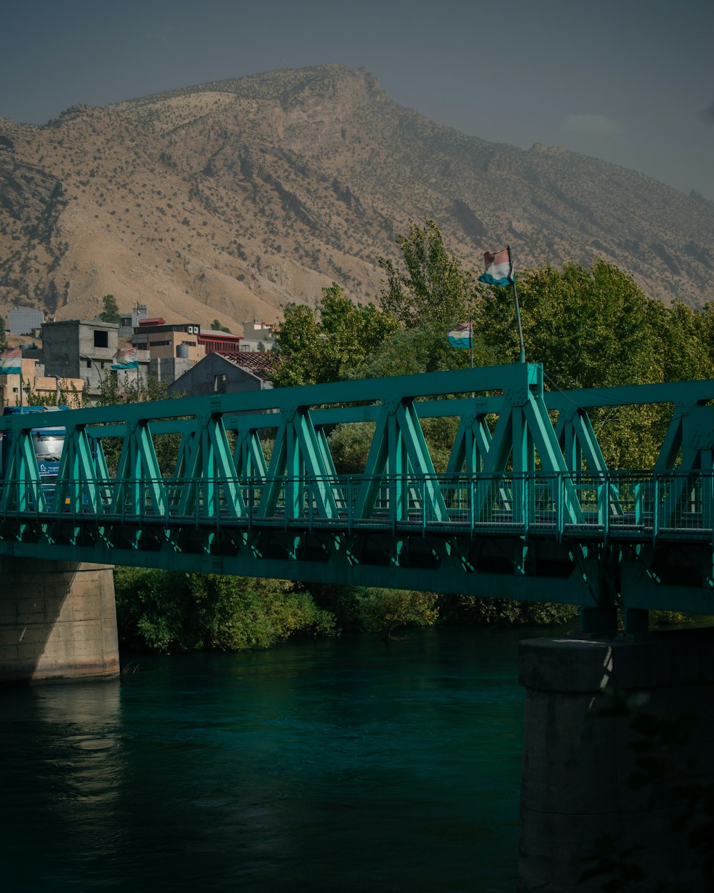 a bridge over a river with a mountain in the background