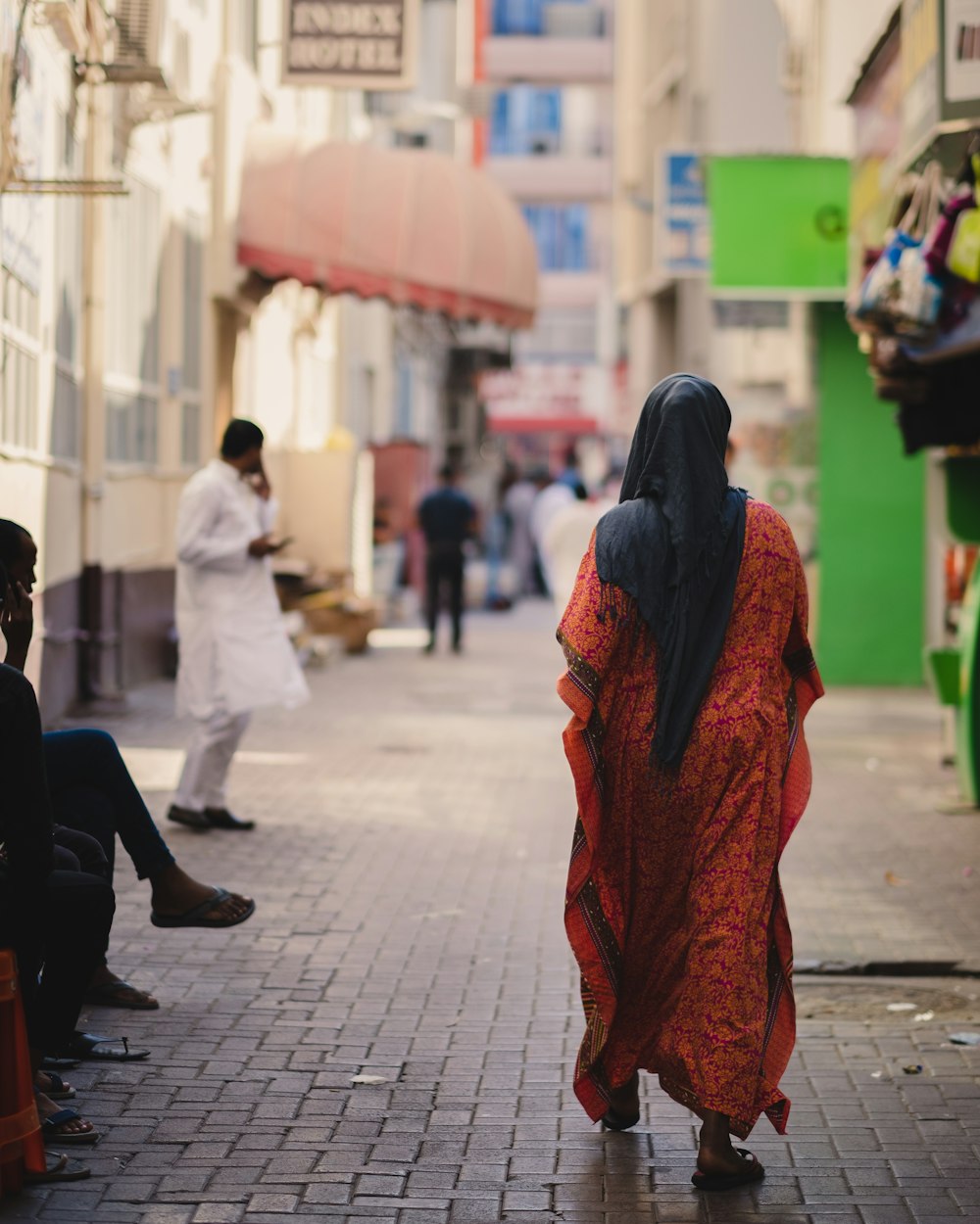 a woman in a red dress walking down a street