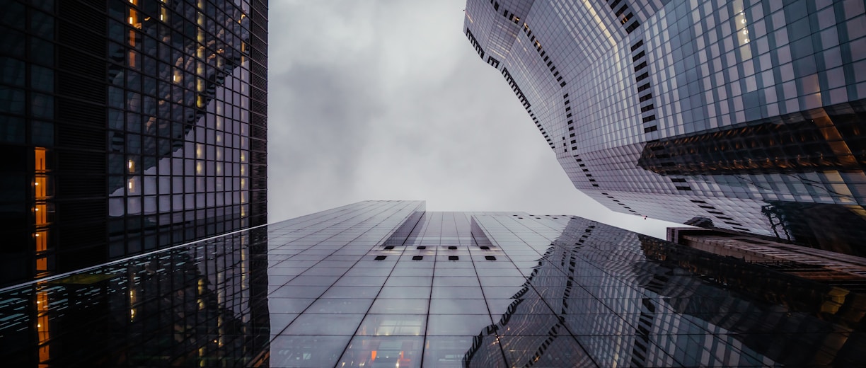 a group of tall buildings with a cloudy sky in the background