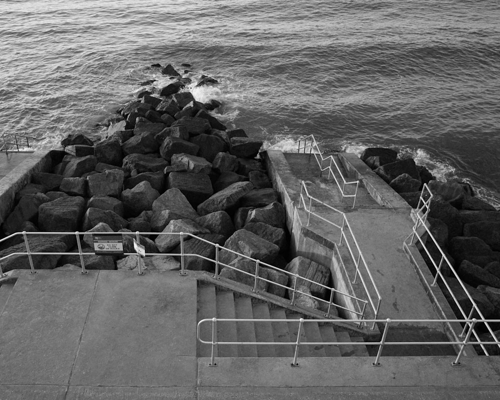 a black and white photo of steps leading to the ocean