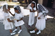 a group of young girls dressed in white standing next to each other