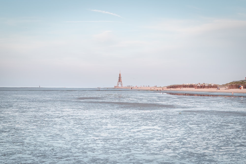 a view of a beach with a lighthouse in the distance