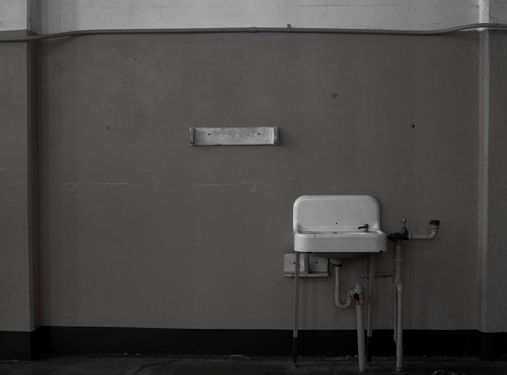 a white sink sitting next to a gray wall