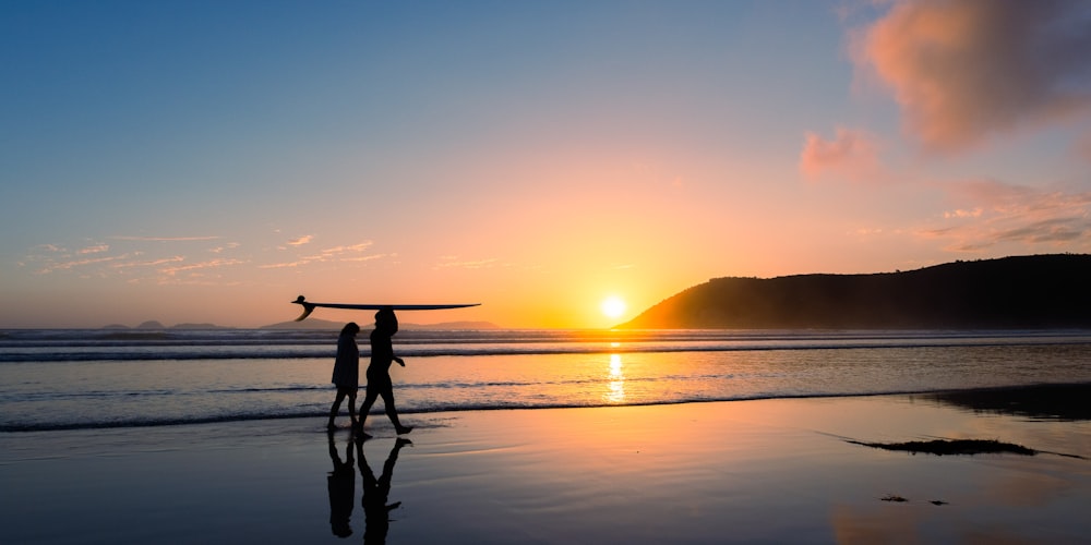 a couple of people standing on top of a beach