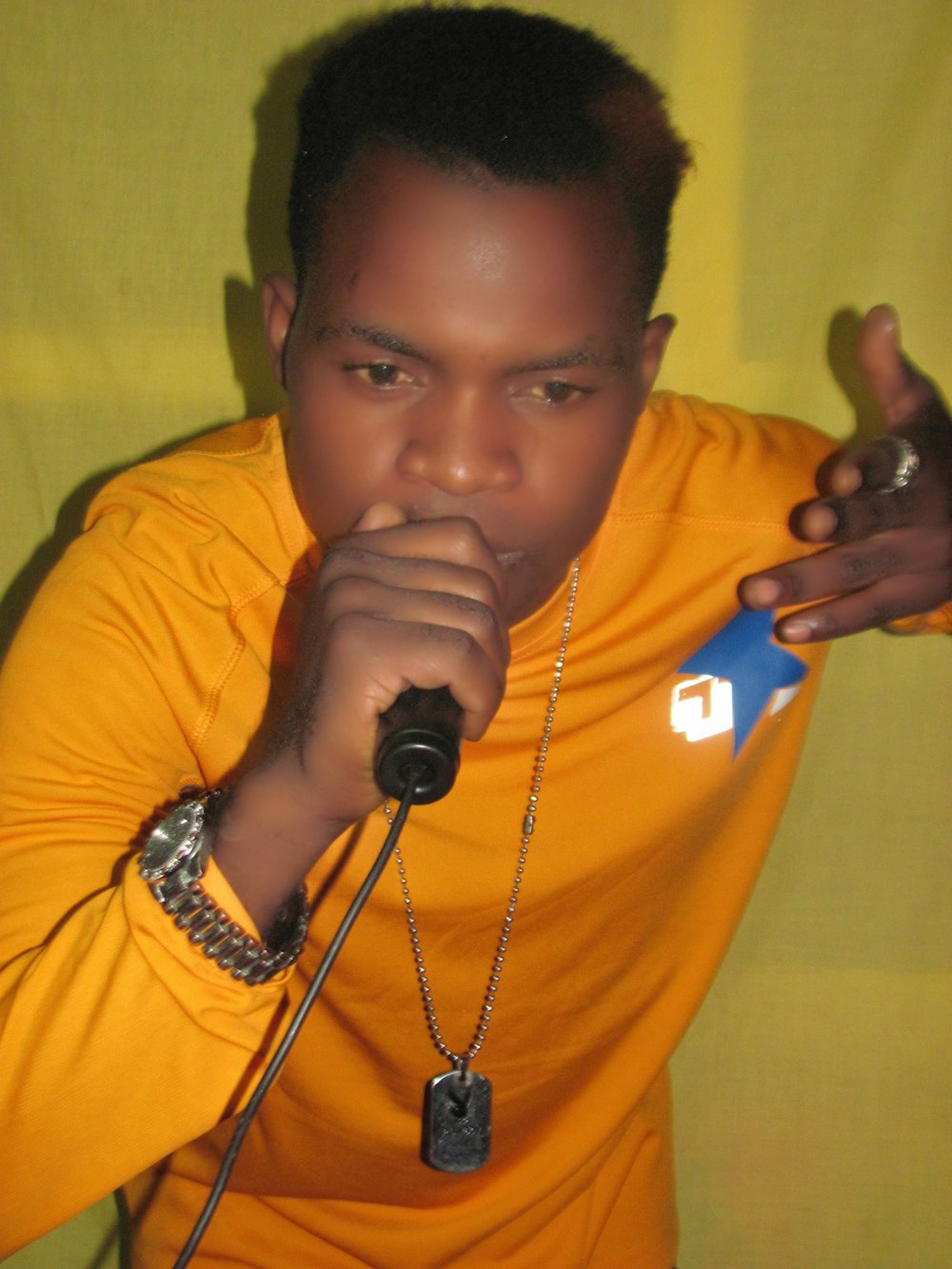 a man in a yellow shirt holding a microphone