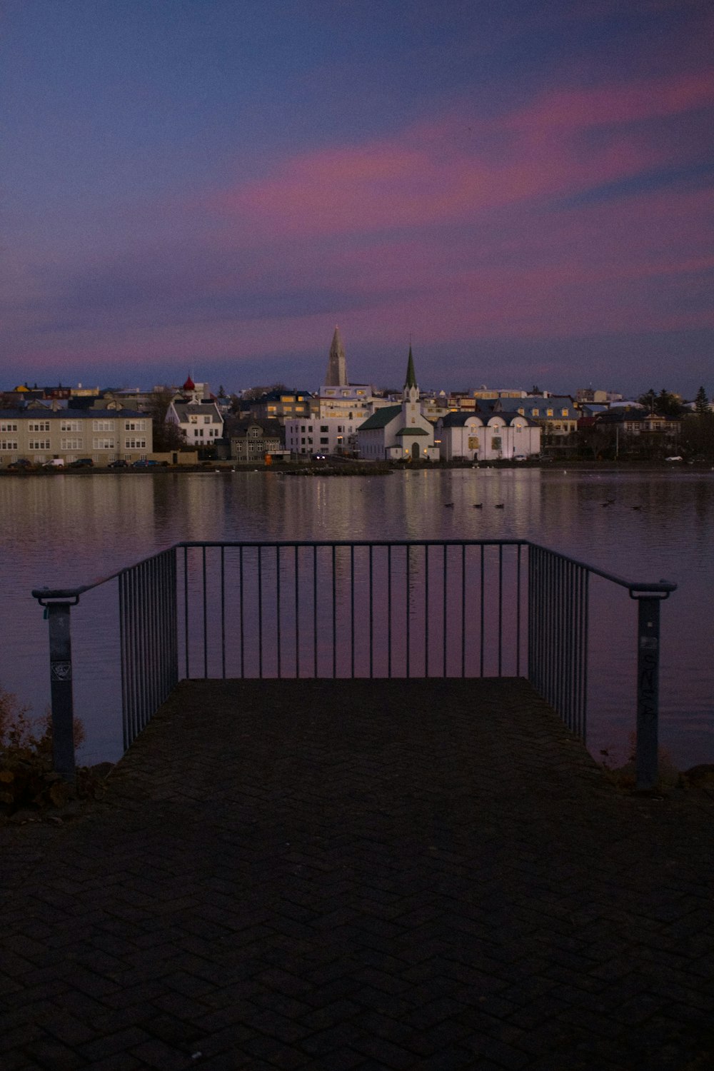 a bench overlooking a body of water with a city in the background