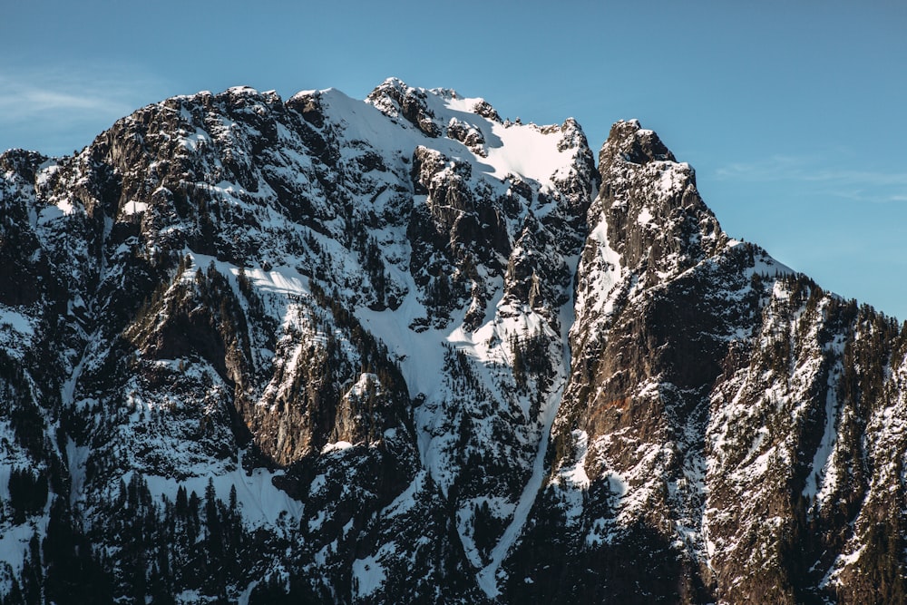 Una montaña cubierta de nieve con un cielo azul en el fondo