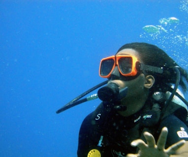 a person wearing a scuba suit and goggles in the water