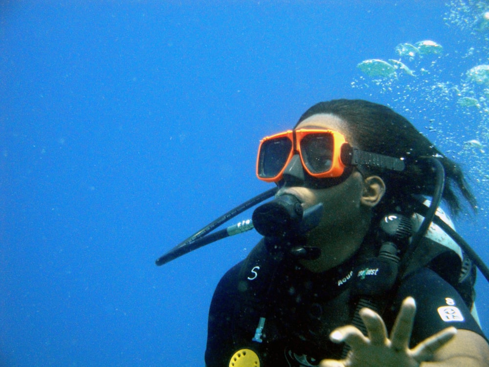 a person wearing a scuba suit and goggles in the water