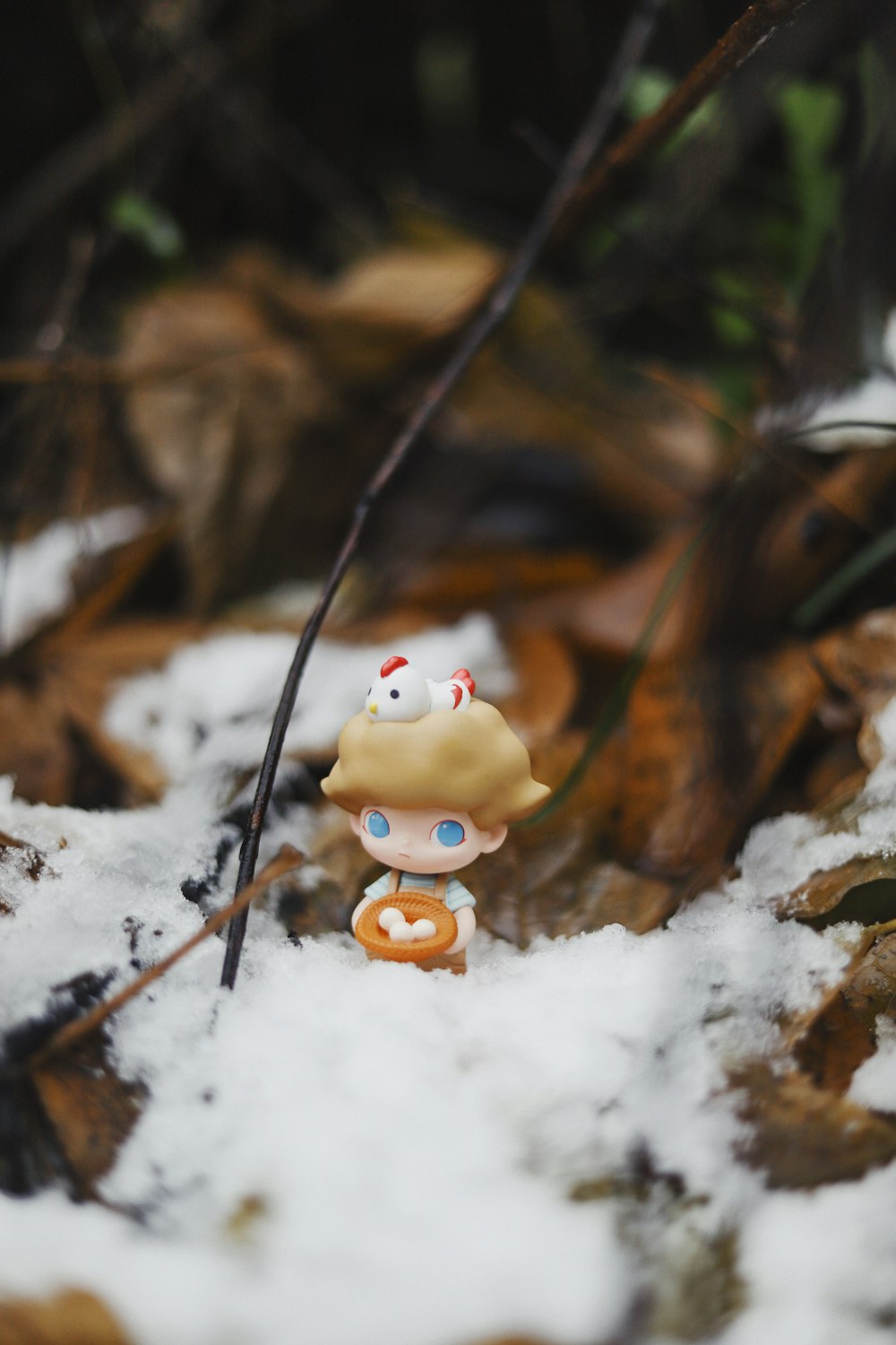 a small doll is standing in the snow