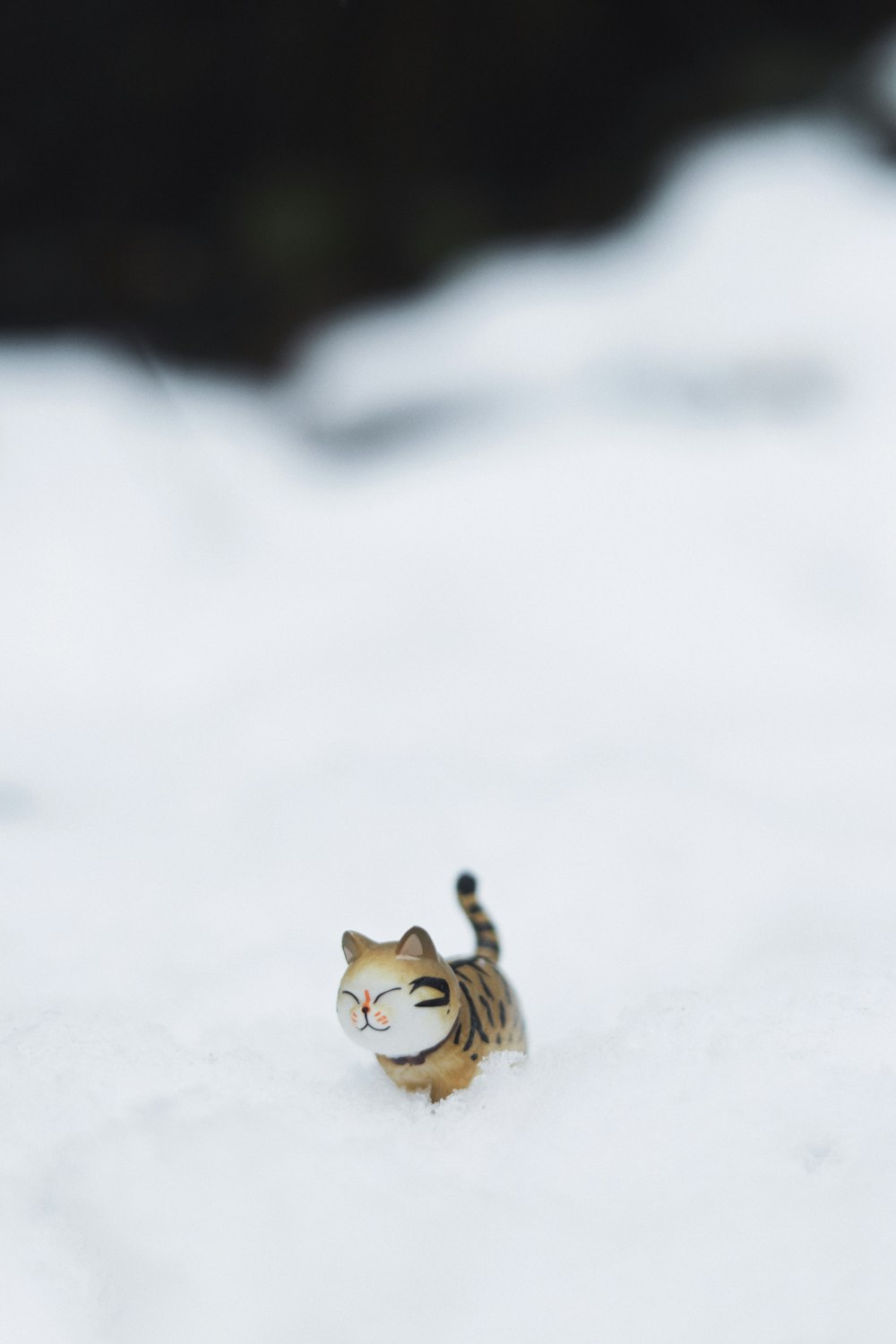 a small toy tiger walking in the snow