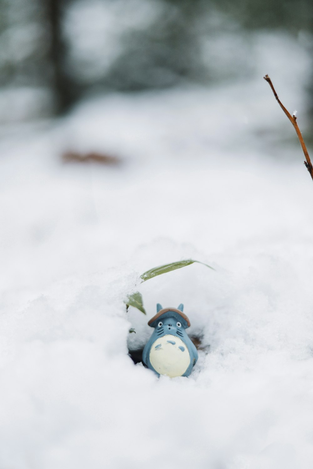 a small toy in the snow with trees in the background