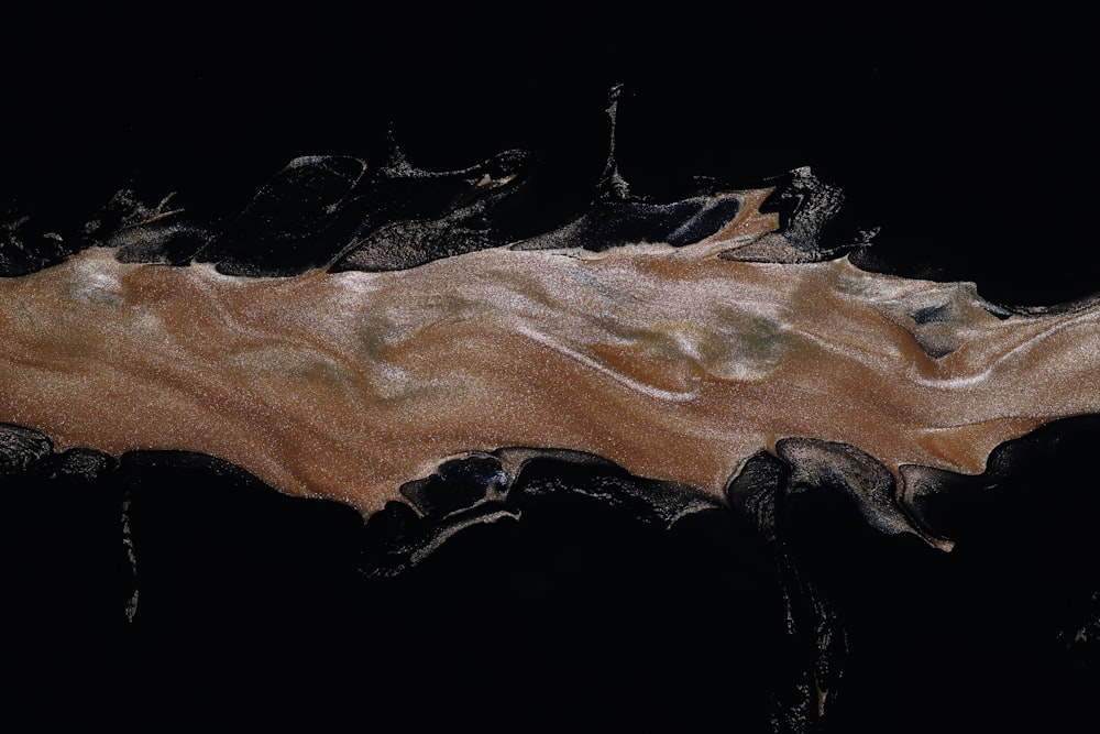 a black and brown painting with a black background