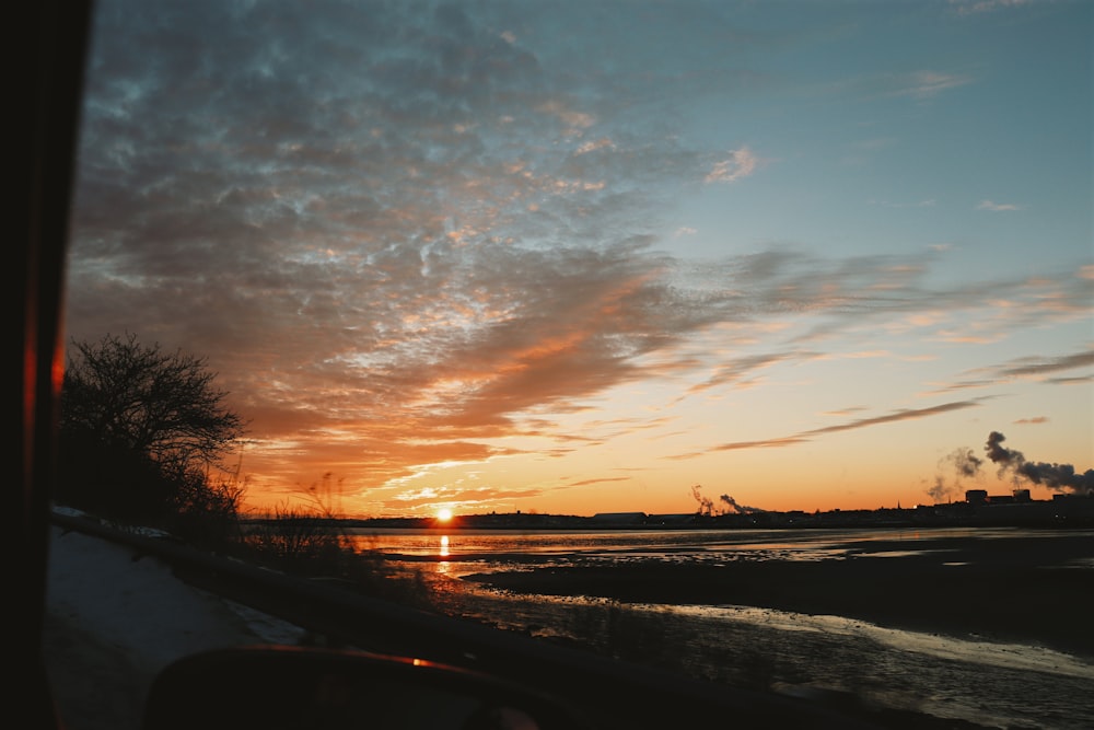 the sun is setting over a body of water